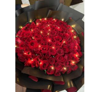 Midnight Ember – 100 Red Roses in Noir Wrap with Fairy Lights