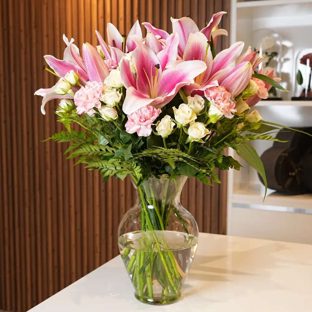 Tender Verse – four pink lilies, six pink carnations,Eight white spray roses